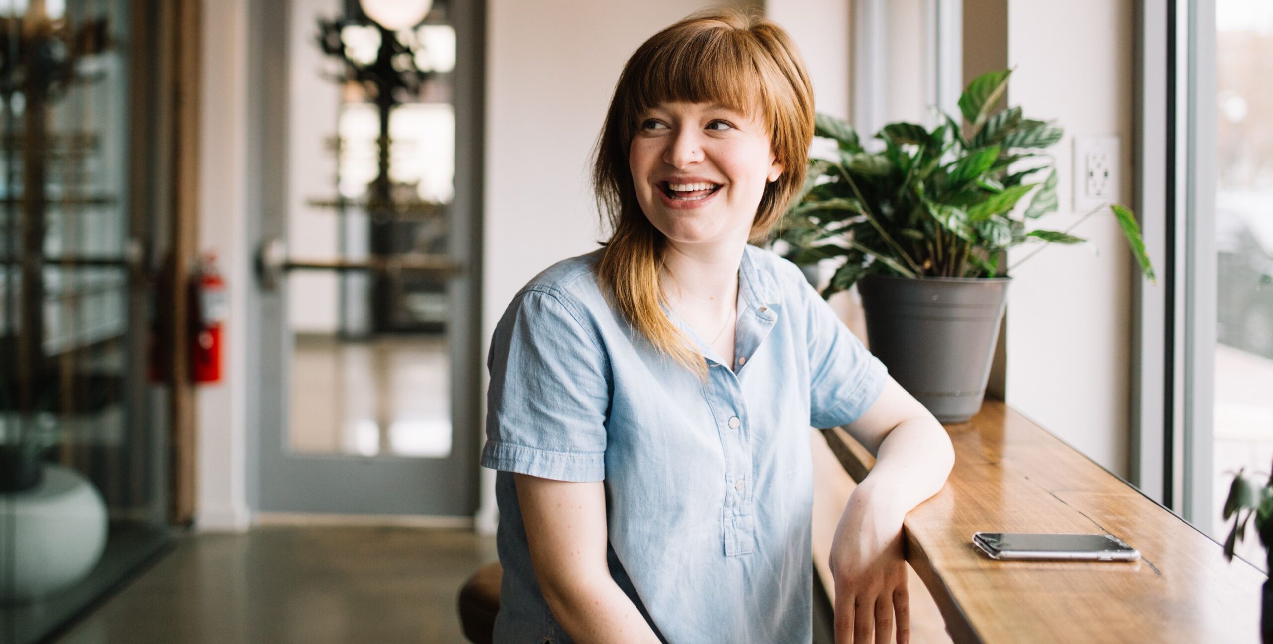 Woman sat at a desk smiling